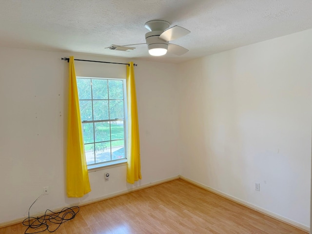 11442 Galbreath Dr, Houston, TX 77066 - empty room with healthy amount of natural light, light wood-style floors, a textured ceiling, ceiling fan, and baseboards