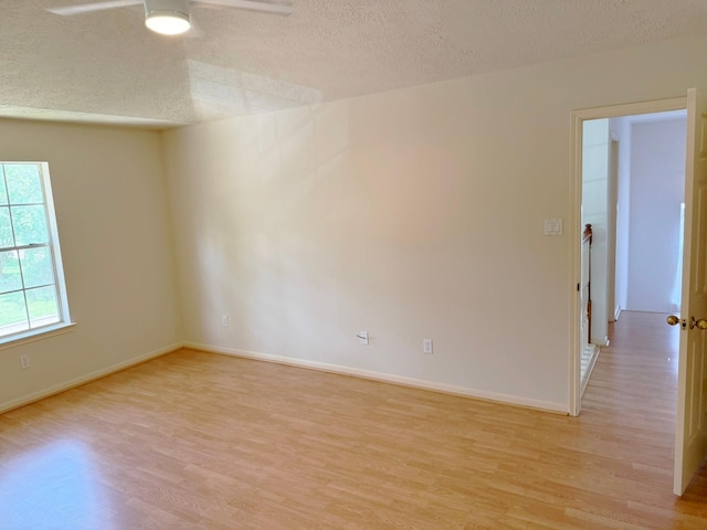 11442 Galbreath Dr, Houston, TX 77066 - empty room with light wood-style floors, a textured ceiling, a ceiling fan, and baseboards