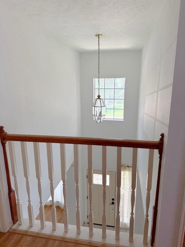 11442 Galbreath Dr, Houston, TX 77066 - stairway featuring a chandelier, wood finished floors, and a textured ceiling