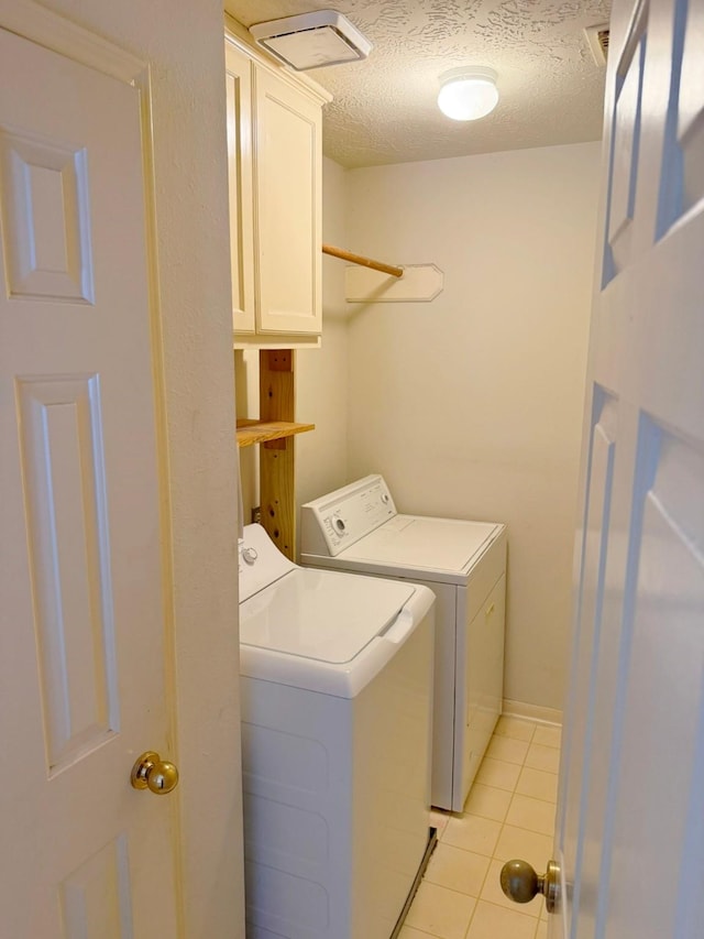 11442 Galbreath Dr, Houston, TX 77066 - laundry area featuring washing machine and clothes dryer, cabinet space, a textured ceiling, and light tile patterned floors