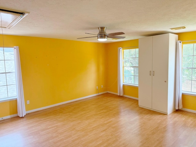 11442 Galbreath Dr, Houston, TX 77066 - spare room with attic access, light wood finished floors, a textured ceiling, baseboards, and ceiling fan