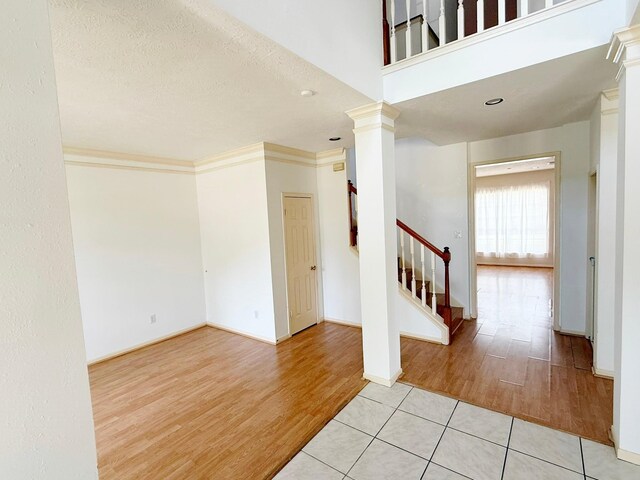 11442 Galbreath Dr, Houston, TX 77066 - entryway featuring wood finished floors, ornate columns, stairs, and baseboards