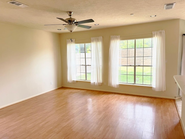 11442 Galbreath Dr, Houston, TX 77066 - empty room with light wood-style flooring, a textured ceiling, a ceiling fan, and baseboards