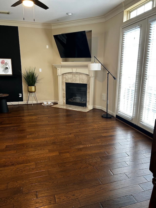 1715 Dominica Dr, Kingwood, TX 77345 - unfurnished living room with a ceiling fan, ornamental molding, wood-type flooring, a tiled fireplace, and baseboards