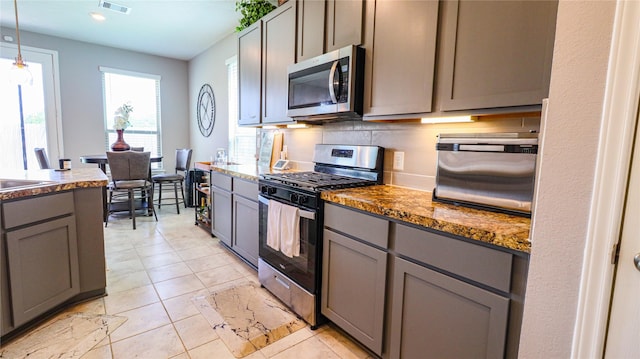 6005 Diamond Sky Ln, Houston, TX 77048 - kitchen with stainless steel appliances, gray cabinetry, hanging light fixtures, light tile patterned flooring, and recessed lighting