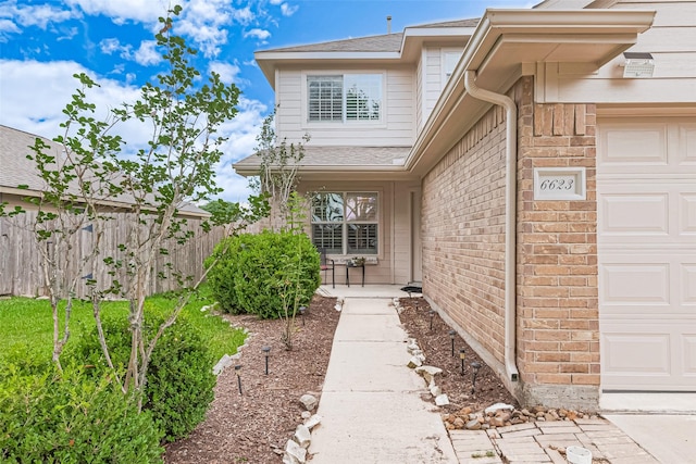 6623 Haven Forest Ln, Richmond, TX 77469 - property entrance featuring an attached garage, a shingled roof, and brick siding