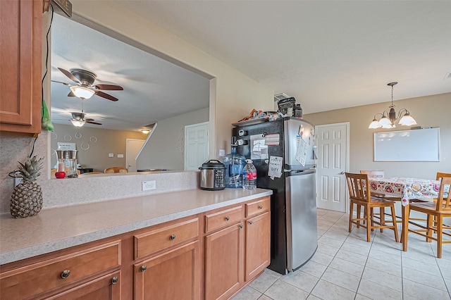 6623 Haven Forest Ln, Richmond, TX 77469 - kitchen with freestanding refrigerator, light tile patterned floors, brown cabinets, and a ceiling fan