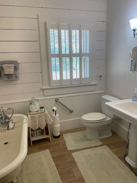 2114 E Lufkin Ave, Lufkin, TX 75901 - bathroom featuring toilet, wood finished floors, and wood walls