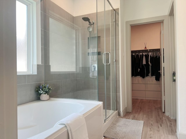10023 Angelina Woods Ln, Conroe, TX 77384 - bathroom with a shower stall, a garden tub, a spacious closet, and wood finished floors