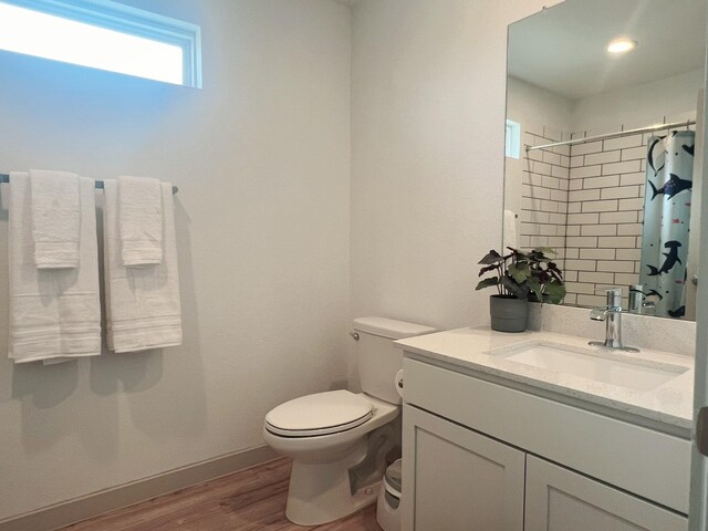 10023 Angelina Woods Ln, Conroe, TX 77384 - bathroom featuring vanity, wood finished floors, toilet, a shower with shower curtain, and baseboards