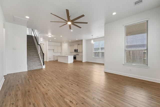 10091 Black Maple Dr, Conroe, TX 77385 - unfurnished living room featuring ceiling fan, light wood finished floors, baseboards, and recessed lighting