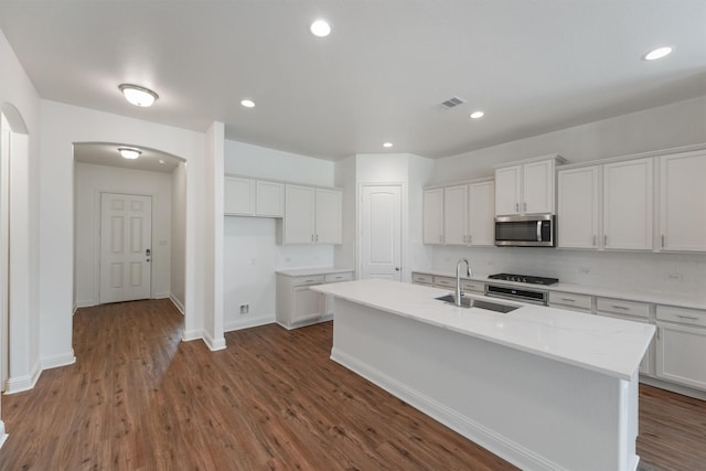 10091 Black Maple Dr, Conroe, TX 77385 - kitchen with stainless steel microwave, a sink, dark wood-style flooring, white cabinetry, and recessed lighting