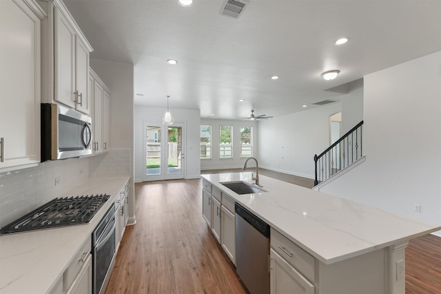 10091 Black Maple Dr, Conroe, TX 77385 - kitchen featuring a sink, appliances with stainless steel finishes, light wood finished floors, recessed lighting, and open floor plan