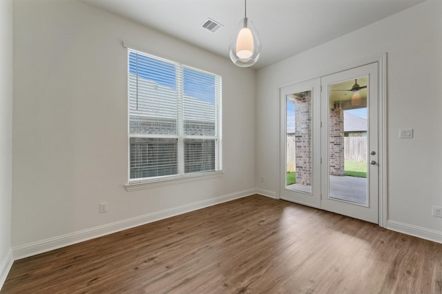 10091 Black Maple Dr, Conroe, TX 77385 - empty room featuring wood finished floors, plenty of natural light, and baseboards