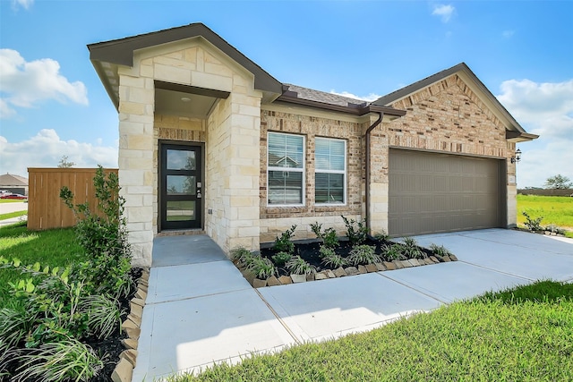 1203 Wildflower Way Dr, Beasley, TX 77417 - view of front of property featuring a garage, stone siding, and driveway