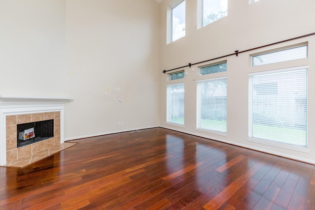 3531 Urban Woods Trl, Houston, TX 77008 - unfurnished living room with hardwood / wood-style floors, plenty of natural light, a tile fireplace, and a towering ceiling