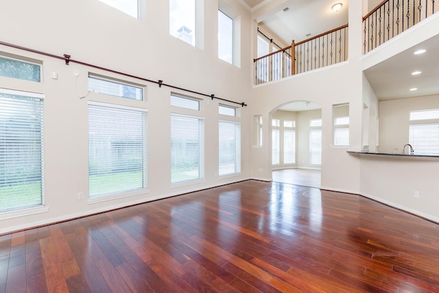 3531 Urban Woods Trl, Houston, TX 77008 - unfurnished living room featuring hardwood / wood-style floors, a high ceiling, and arched walkways