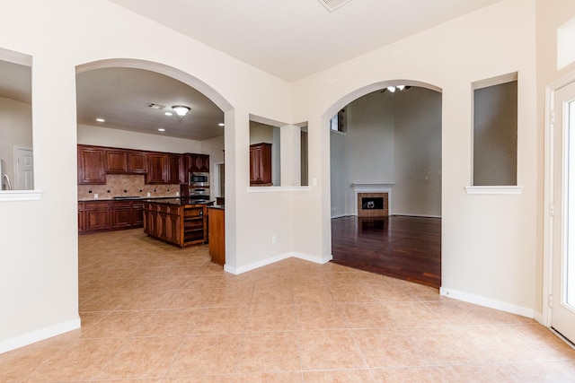 3531 Urban Woods Trl, Houston, TX 77008 - kitchen with stainless steel appliances, light tile patterned floors, dark countertops, decorative backsplash, and open floor plan