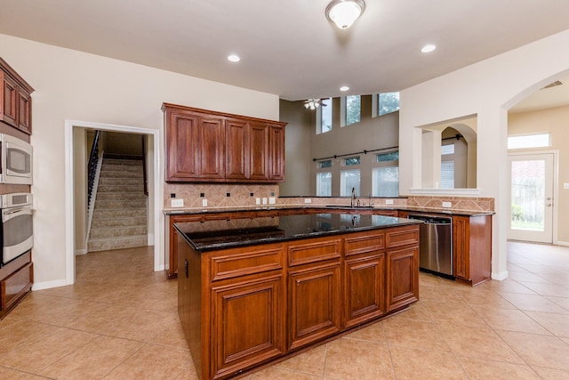 3531 Urban Woods Trl, Houston, TX 77008 - kitchen featuring appliances with stainless steel finishes, backsplash, ceiling fan, arched walkways, and light tile patterned flooring
