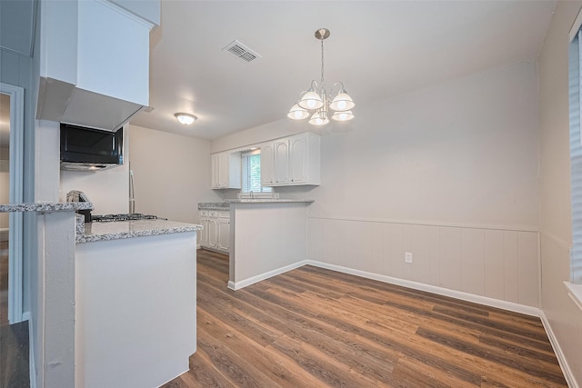 9003 Chateau Forest Dr, Houston, TX 77088 - kitchen featuring white cabinets, dark wood finished floors, a chandelier, a peninsula, and pendant lighting