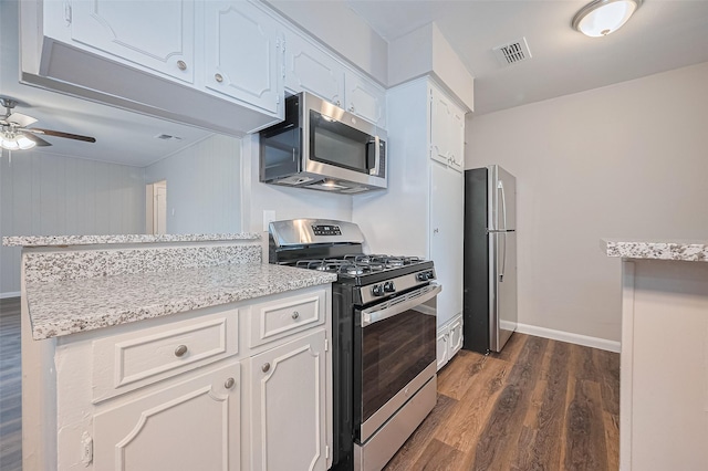 9003 Chateau Forest Dr, Houston, TX 77088 - kitchen featuring stainless steel appliances, dark wood-type flooring, ceiling fan, white cabinetry, and light stone countertops