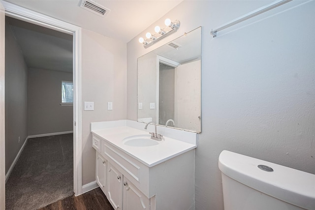 9003 Chateau Forest Dr, Houston, TX 77088 - half bathroom with vanity, wood finished floors, toilet, and baseboards