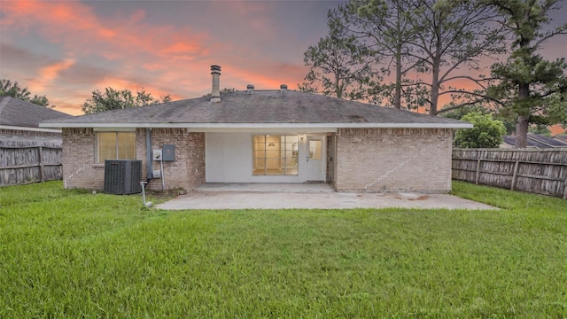 10622 Highland Woods Dr, Sugar Land, TX 77498 - back of house at dusk featuring central air condition unit, a patio area, and brick siding