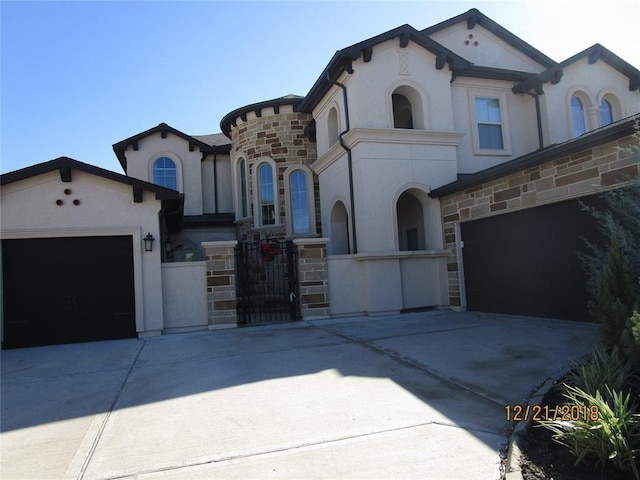 11115 Cornalee Ct, Richmond, TX 77407 - view of front facade with concrete driveway, stone siding, stucco siding, an attached garage, and a gate