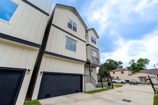 2310 Reinerman St, Houston, TX 77007 - view of front of house with board and batten siding, an attached garage, and driveway