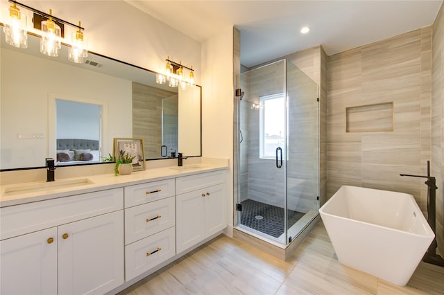 2310 Reinerman St, Houston, TX 77007 - bathroom with double vanity, a shower stall, a freestanding tub, connected bathroom, and tile patterned floors