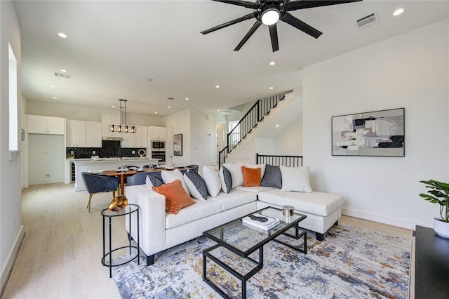 2310 Reinerman St, Houston, TX 77007 - living room with ceiling fan, light wood-type flooring, recessed lighting, baseboards, and stairway