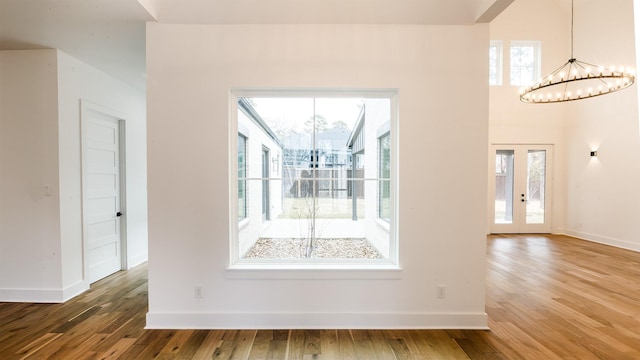 4785 W Fork Blvd, Conroe, TX 77304 - empty room with a chandelier, wood finished floors, plenty of natural light, and baseboards