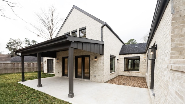 4785 W Fork Blvd, Conroe, TX 77304 - rear view of house with a patio, brick siding, and roof with shingles