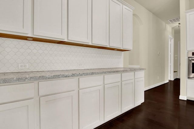 12406 Fort Isabella Ct, Tomball, TX 77375 - kitchen with dark wood finished floors, white cabinetry, decorative backsplash, and oven