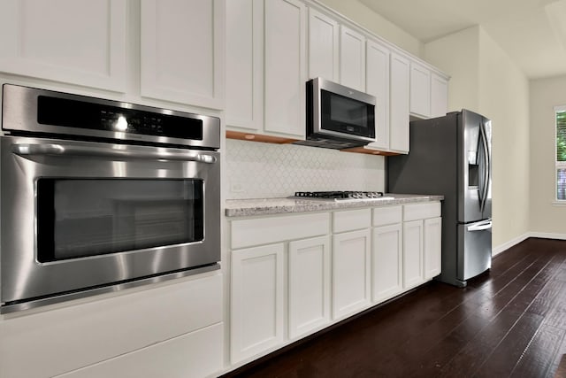 12406 Fort Isabella Ct, Tomball, TX 77375 - kitchen with stainless steel appliances, tasteful backsplash, dark wood-style floors, white cabinetry, and baseboards
