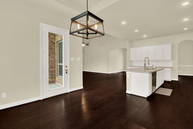 12406 Fort Isabella Ct, Tomball, TX 77375 - kitchen with arched walkways, a sink, dishwasher, recessed lighting, and an island with sink