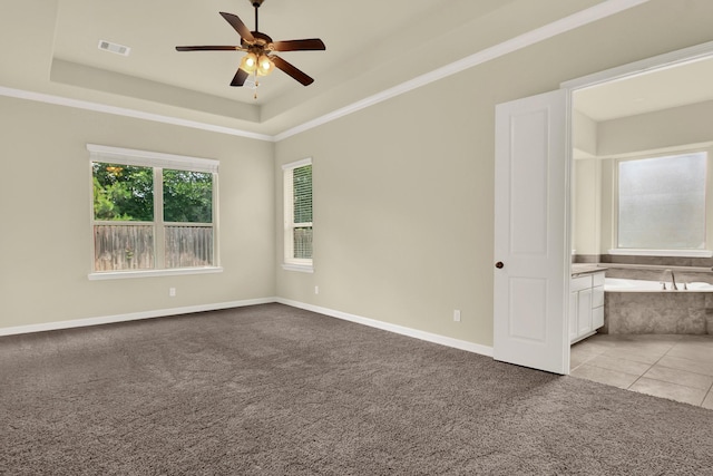 12406 Fort Isabella Ct, Tomball, TX 77375 - spare room featuring light carpet, a ceiling fan, a raised ceiling, and baseboards