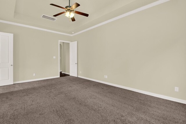 12406 Fort Isabella Ct, Tomball, TX 77375 - unfurnished room featuring a tray ceiling, a ceiling fan, dark carpet, ornamental molding, and baseboards