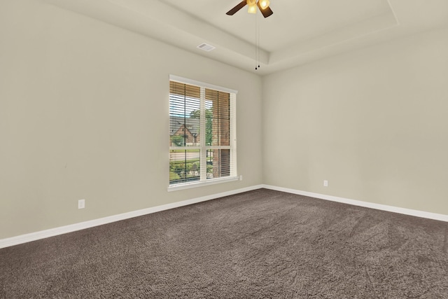 12406 Fort Isabella Ct, Tomball, TX 77375 - spare room with dark carpet, ceiling fan, a raised ceiling, and baseboards
