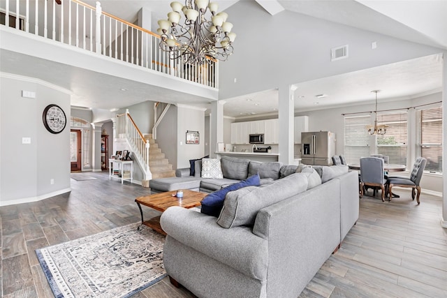 2907 Silverberry Trl, Houston, TX 77345 - living area featuring a chandelier, high vaulted ceiling, light wood-style floors, stairs, and baseboards
