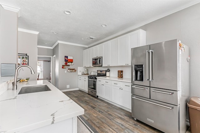2907 Silverberry Trl, Houston, TX 77345 - kitchen featuring stainless steel appliances, a sink, dark wood-style flooring, white cabinets, and crown molding