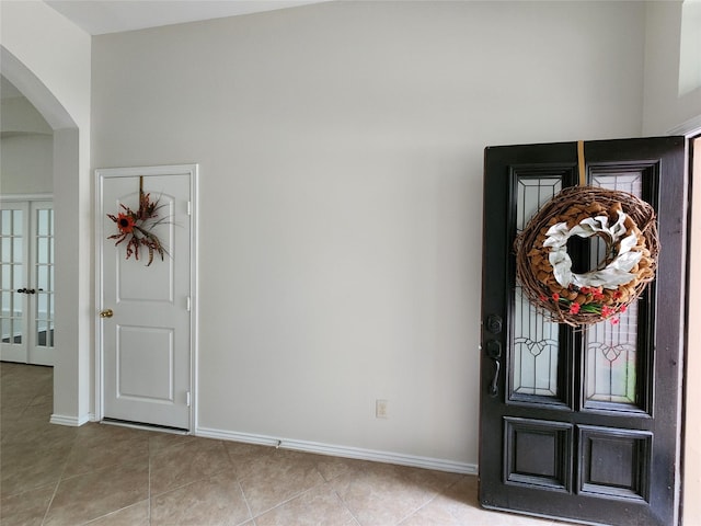 13705 Rainwater Dr, Pearland, TX 77584 - entrance foyer featuring arched walkways, light tile patterned floors, baseboards, and french doors