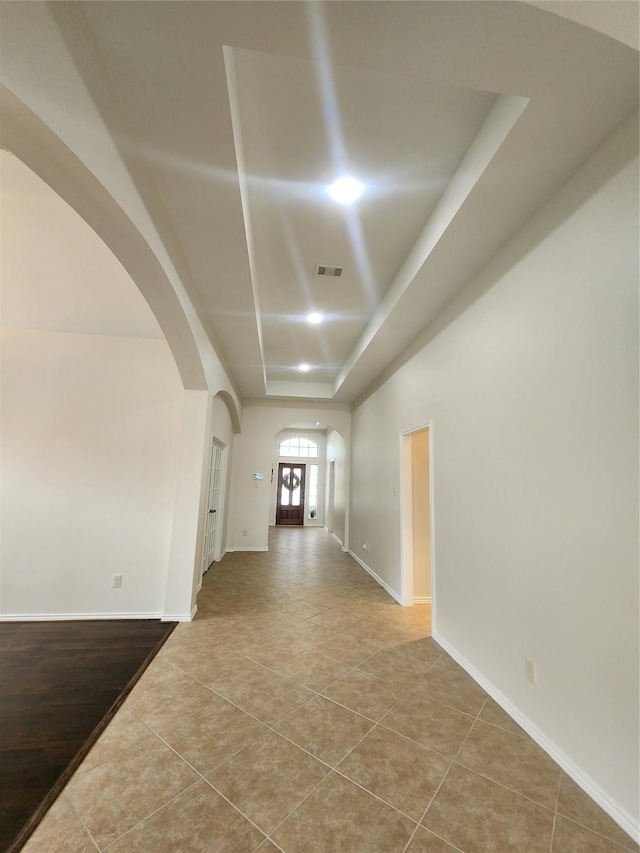 13705 Rainwater Dr, Pearland, TX 77584 - hall featuring arched walkways, a raised ceiling, tile patterned flooring, and baseboards