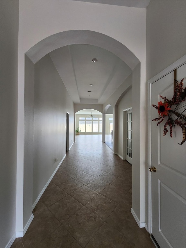 13705 Rainwater Dr, Pearland, TX 77584 - hallway with baseboards, arched walkways, and a raised ceiling