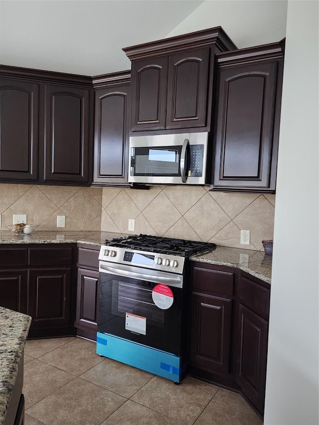 13705 Rainwater Dr, Pearland, TX 77584 - kitchen with appliances with stainless steel finishes, light stone counters, tasteful backsplash, and dark brown cabinetry