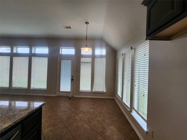 13705 Rainwater Dr, Pearland, TX 77584 - unfurnished dining area featuring dark tile patterned flooring, vaulted ceiling, and baseboards