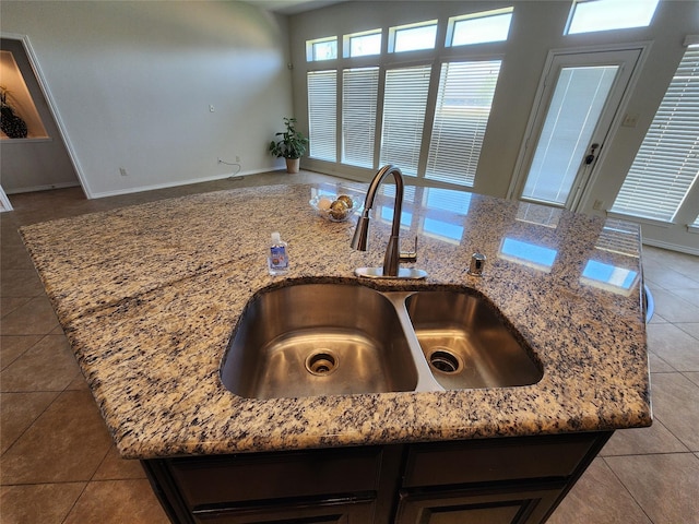 13705 Rainwater Dr, Pearland, TX 77584 - kitchen view of a sink, light stone countertops, baseboards, and a center island with sink