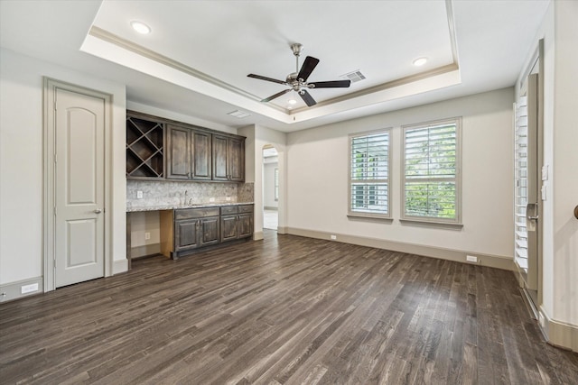 12710 Pebblebrook Dr, Houston, TX 77024 - unfurnished living room featuring a tray ceiling, dark wood-style floors, ceiling fan, a sink, and recessed lighting