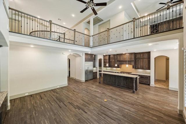 12710 Pebblebrook Dr, Houston, TX 77024 - unfurnished living room with arched walkways, a ceiling fan, a high ceiling, dark wood finished floors, and baseboards