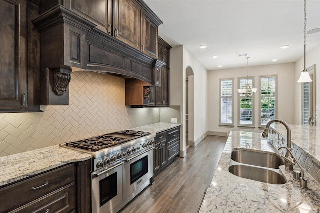 12710 Pebblebrook Dr, Houston, TX 77024 - kitchen featuring a sink, range with two ovens, a chandelier, tasteful backsplash, and dark brown cabinets